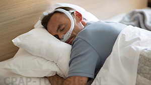 homme dort au lit avec Masque narinaire Philips